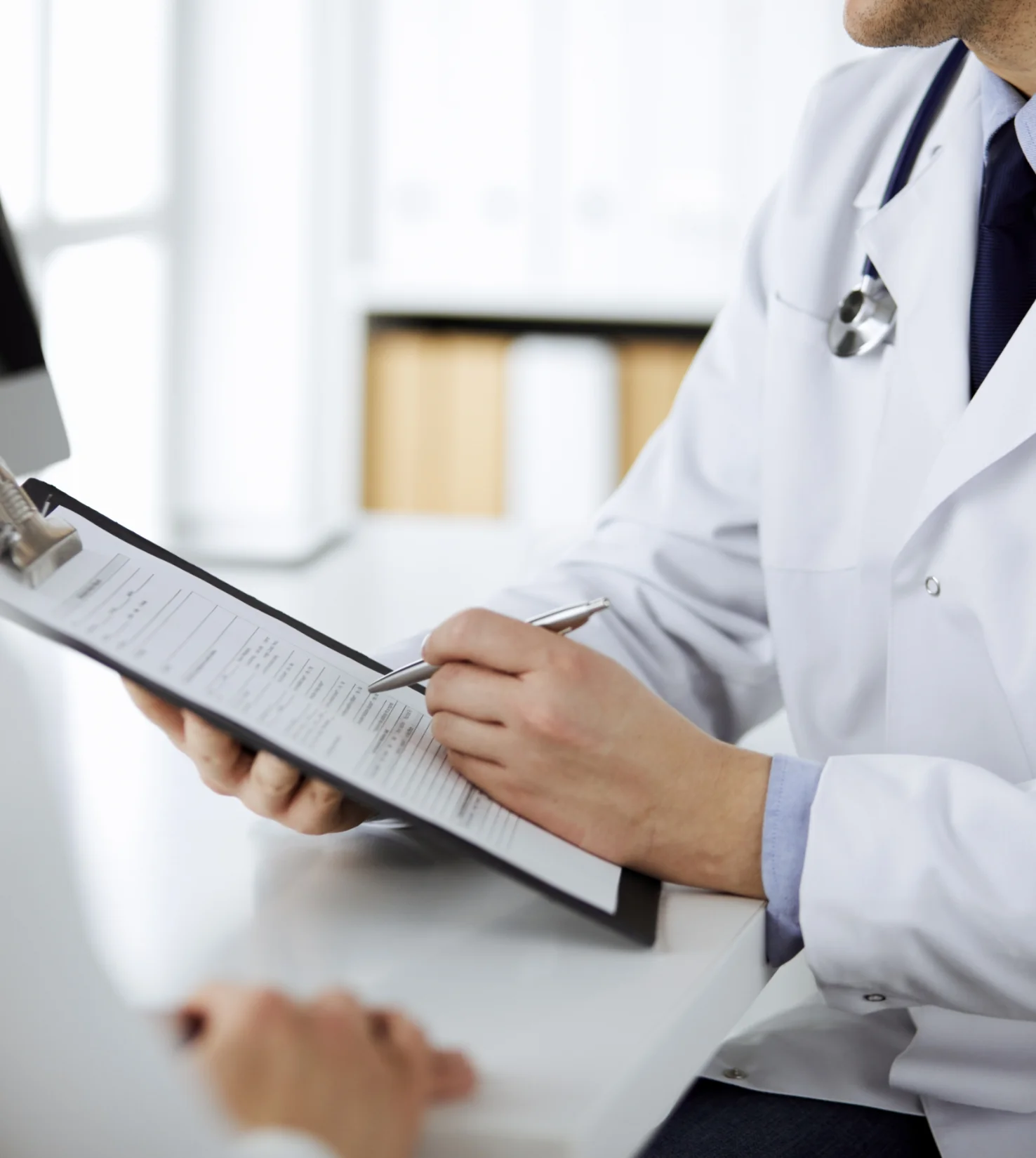 医師がカルテにペンで記入している様子
