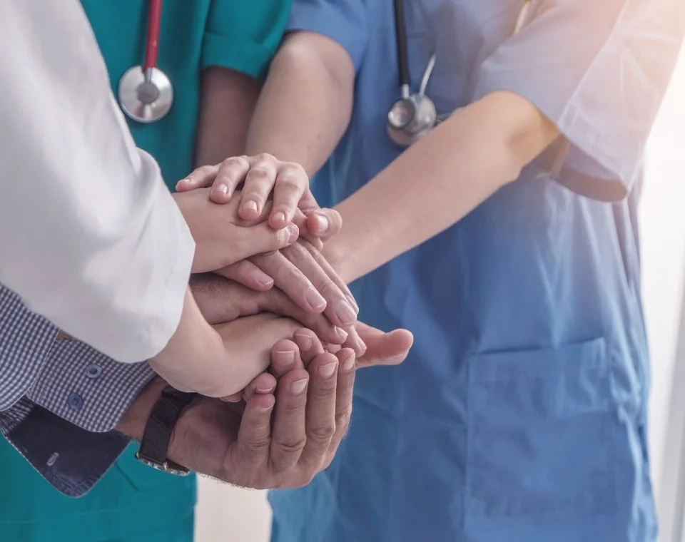 医療チームが手を重ねて協力している様子