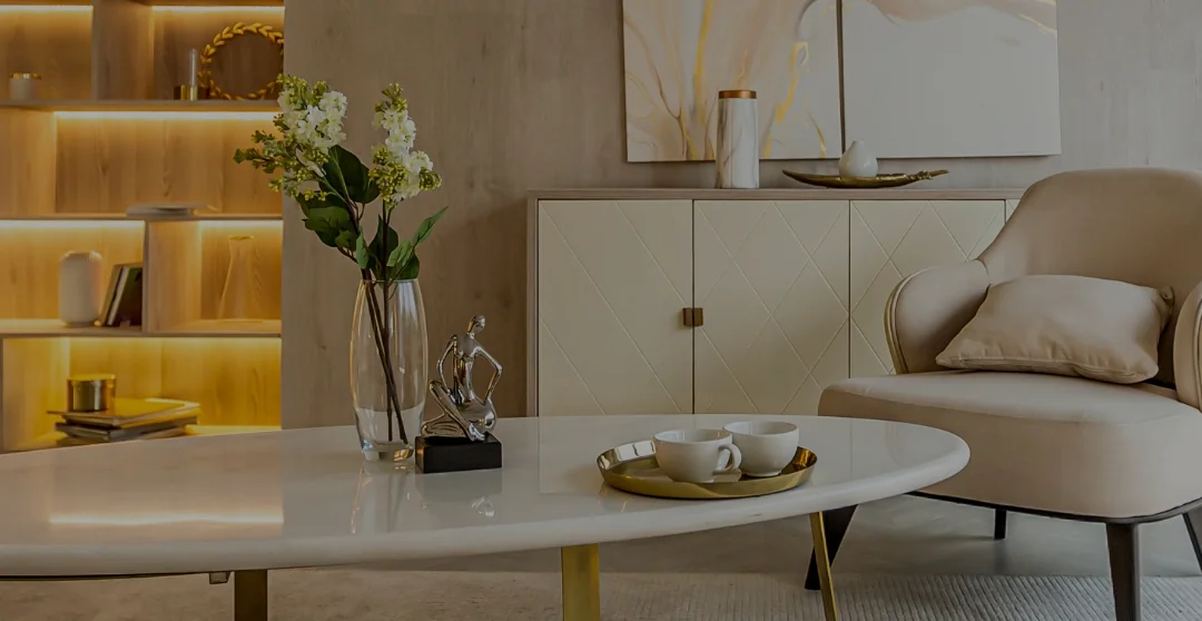 花瓶、彫刻、カップが置かれたテーブルと、肘掛け椅子のある室内