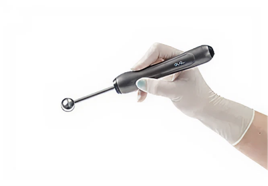 手袋をはめた手が、先端にボールのついた医療器具を持っている。