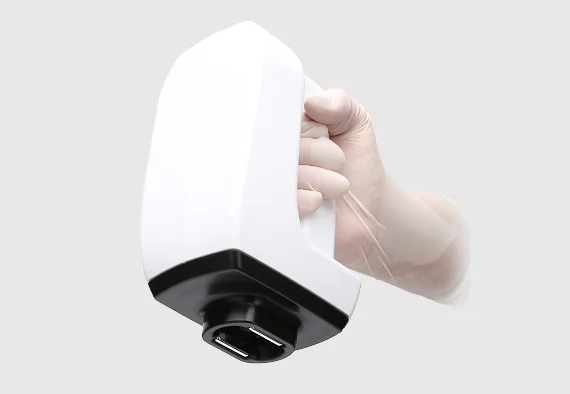 白手袋をはめた手が、インモードの白い医療機器を持っている。