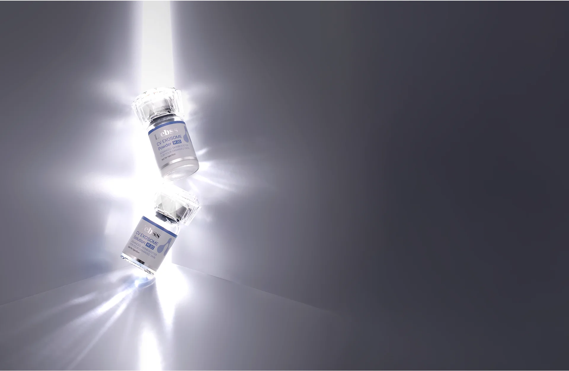 光が当たる背景に、エレベスの美容液ボトルが2本斜めに配置されている。