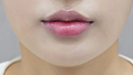 ふっくらとした、ピンク色のリップのクローズアップ。