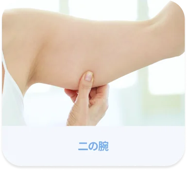 女性が二の腕の皮膚をつまんでいる様子